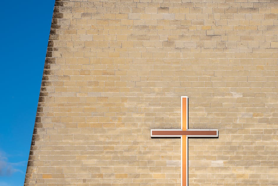 Minimalist wall cross against a blue sky