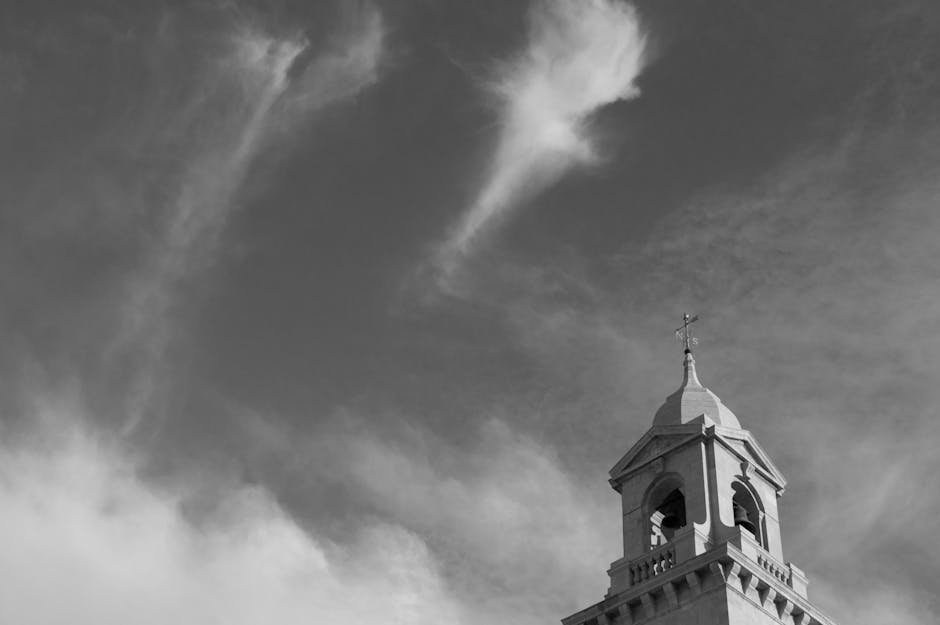 Dramatic church tower against cloudy sky